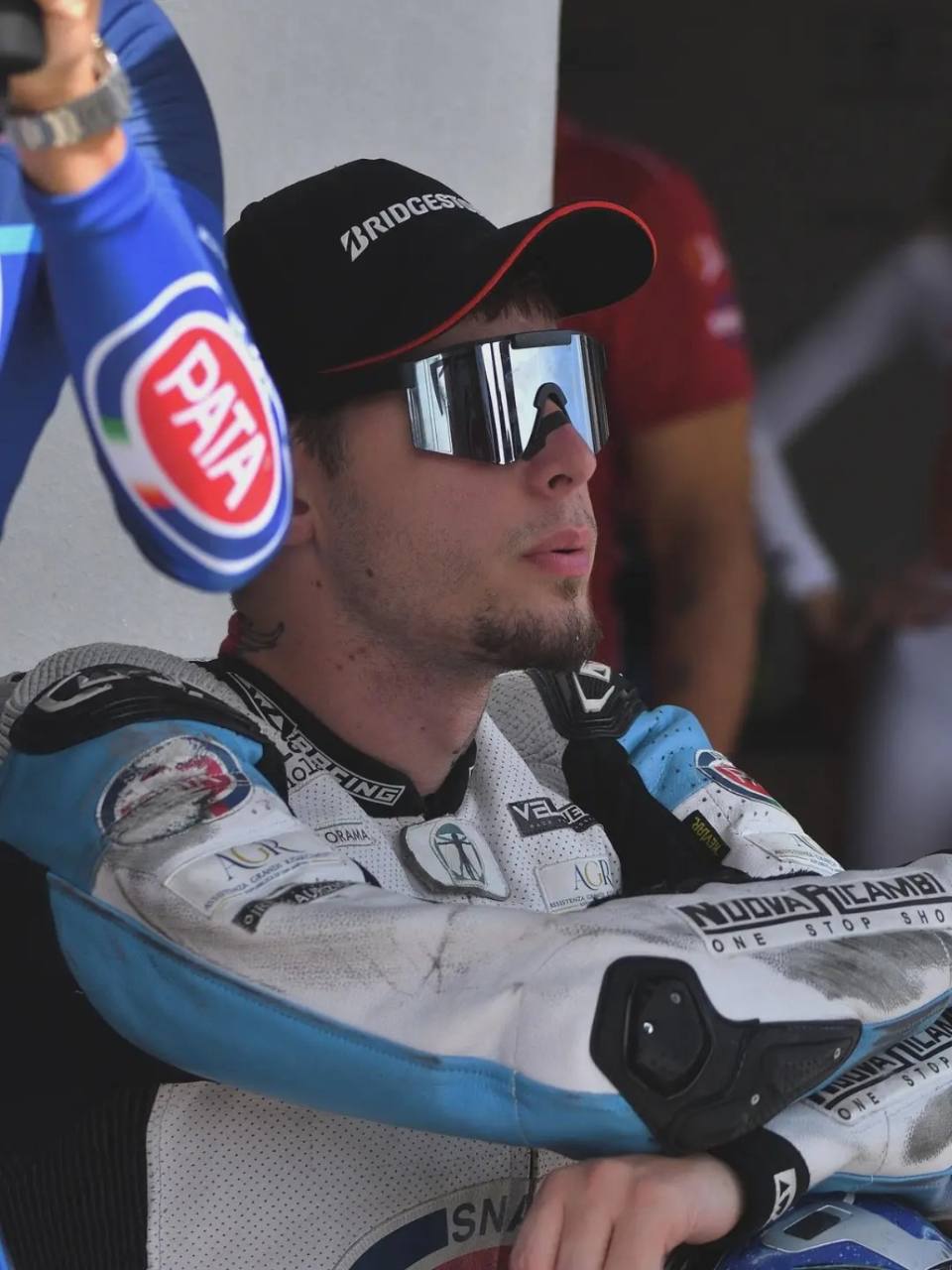 Ritratto di Omar in tuta da gara, con cappellino e occhiali da sole